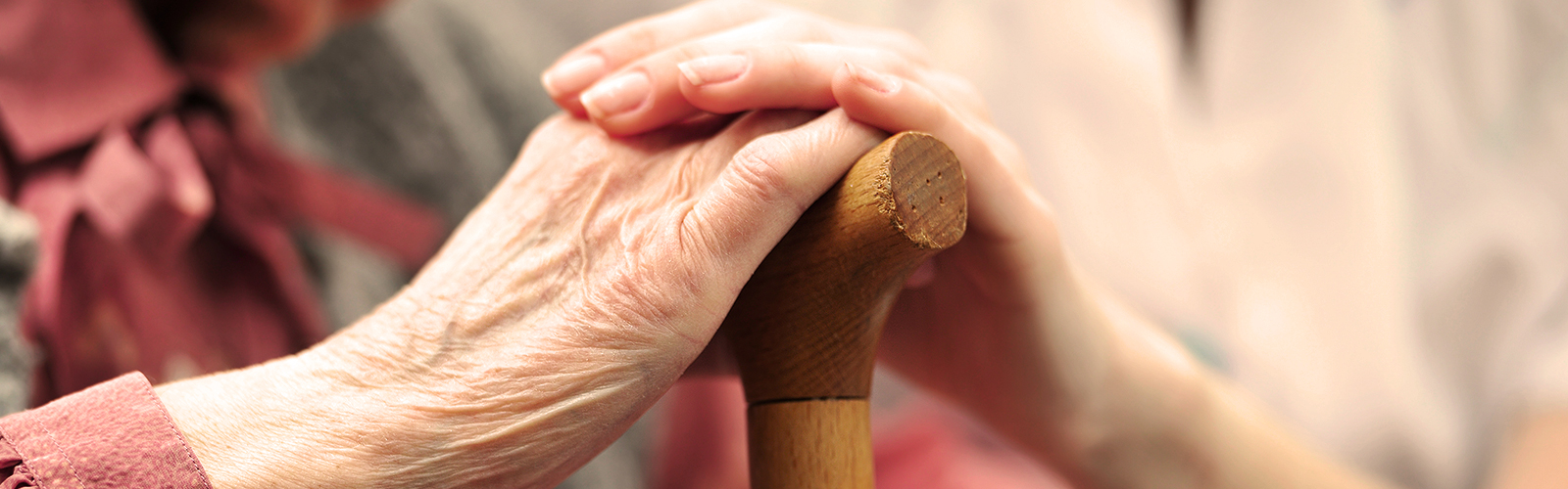 Elderly woman holding hands with younger woman Elderly woman holding hands with younger woman